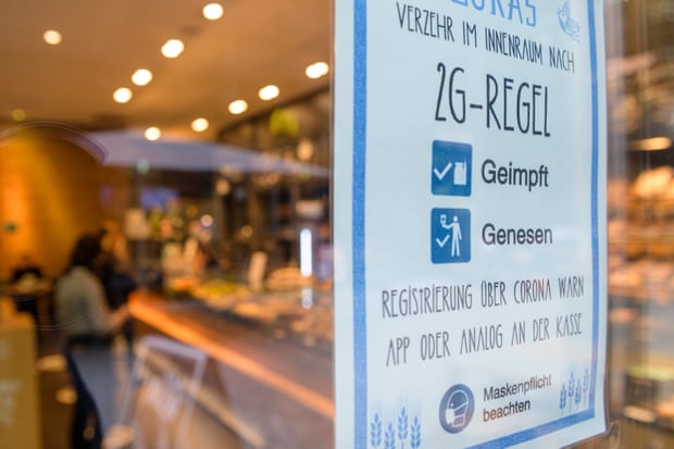 Një tabelë që tregon hyrjen vetëm për "2G" - termi në gjermanisht për njerëzit që janë ose të vaksinuar kundër (geimpft) ose të shëruar nga (genesen) koronavirus, varet në hyrje të një kafeneje në Leipzig. Fotografia: Jens Schlueter/Getty